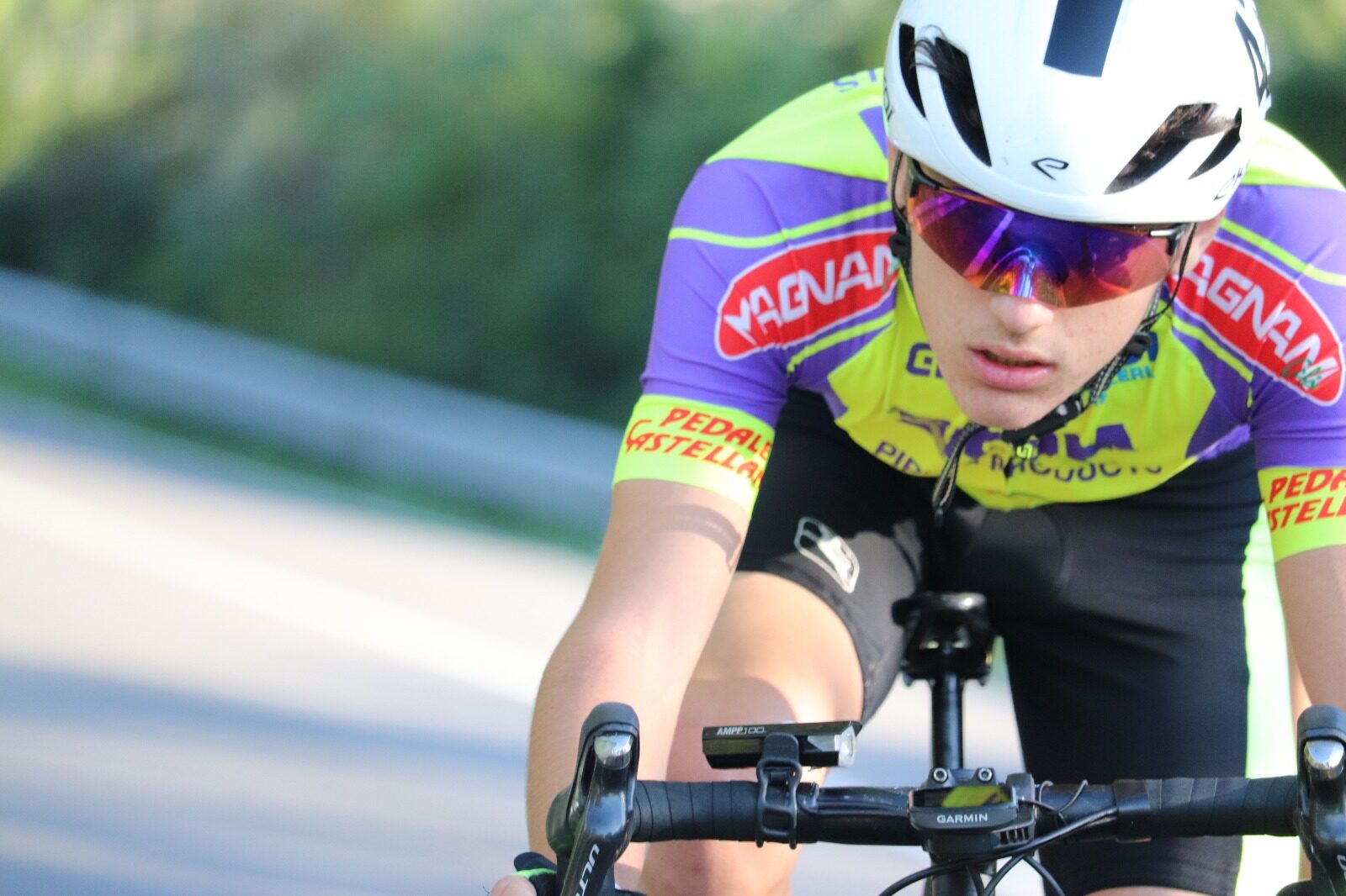 Edoardo in posizione aerodinamica sul manubrio durante una gara, maglia del Pedale Castellano